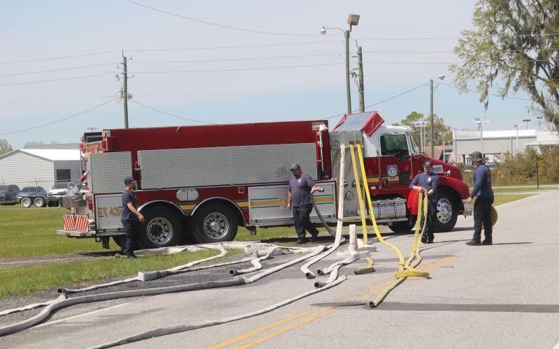 Columbia County Fire Rescue firefighters Joshua Chase, Ryan Jenkins, Cameron McCauley and Blake Heckman inspect a variety hoses as they prepare for a potential busy fire season. (TONY BRITT/Lake City Reporter)