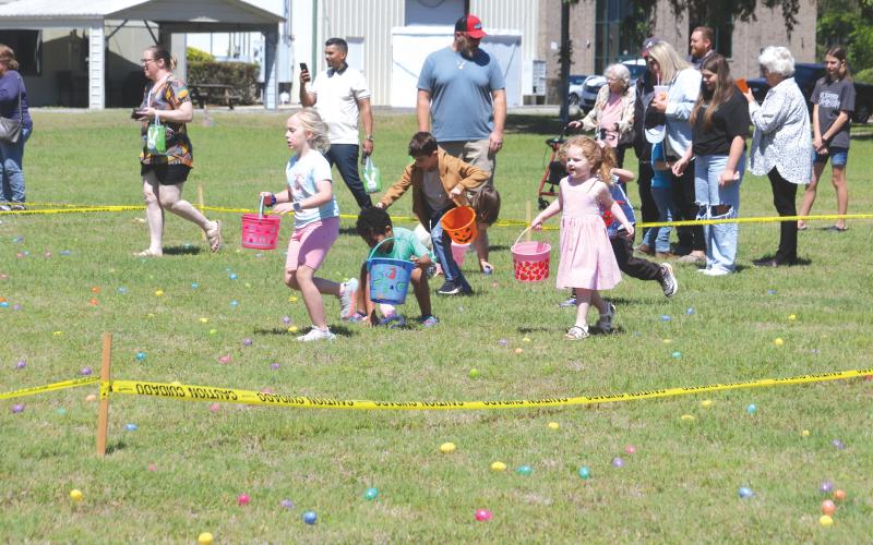 Kids race to gather Easter eggs during the Easter Extravaganza put on by The Canopy at Harper Lake on Saturday afternoon. (TONY BRITT/Lake City Reporter)