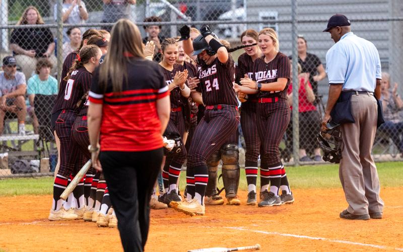 Fort White pitcher Kadence Compton celebrates at home plate with her teammates after hitting a two-run home run during Tuesday's 3-1 win over Suwannee. (JACK HOWDESHELL/Lake City Reporter)