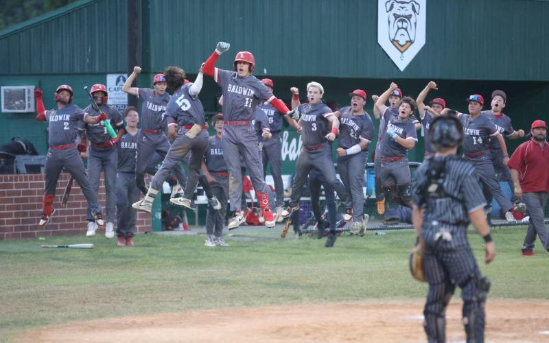 Baldwin's Turner Farah celebrates with teammates after hitting a home run while Suwannee catcher Grayson Bonds looks on during Game 2 of the Region 1-3A quarterfinals on Tuesday. (PAUL BUCHANAN/Lake City Reporter)