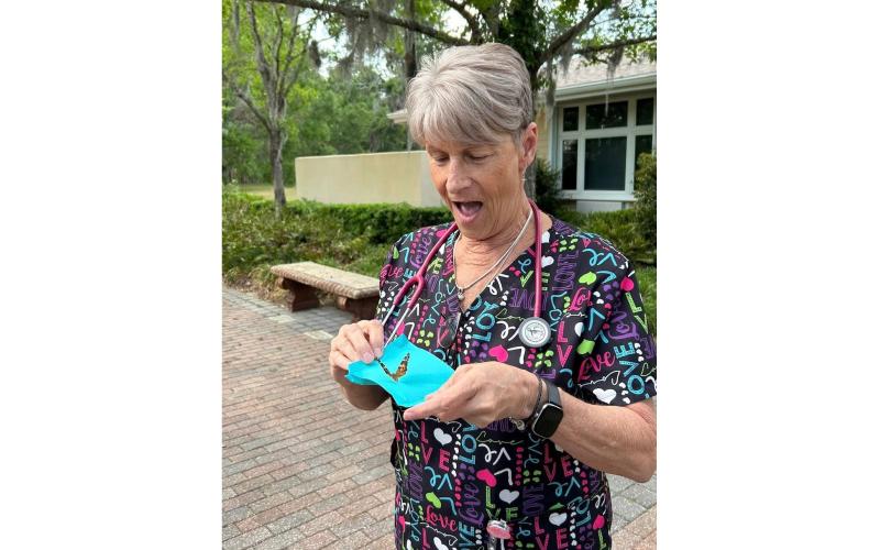 Haven Hospice registered nurse Cindy Romero readies to release one of the butterflies in the Butterfly Memorial Program event Thursday. (COURTESY)