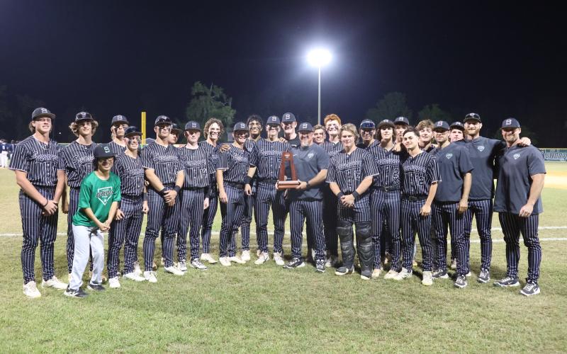 Suwannee's baseball team poses with the District 3-3A trophy after defeating Paxon 10-0 on Thursday. (PAUL BUCHANAN/Lake City Reporter)