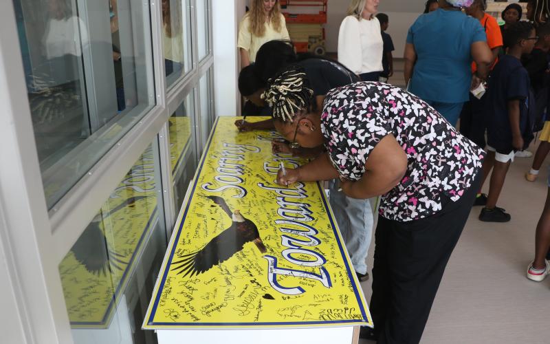 Tanika Dorsey, who has a pair of twins set to attend Niblack as fifth graders next school year, autographs a Niblack sign in the cafeteria of the new Niblack Elementary building. (MORGAN MCMULLEN/Lake City Reporter)