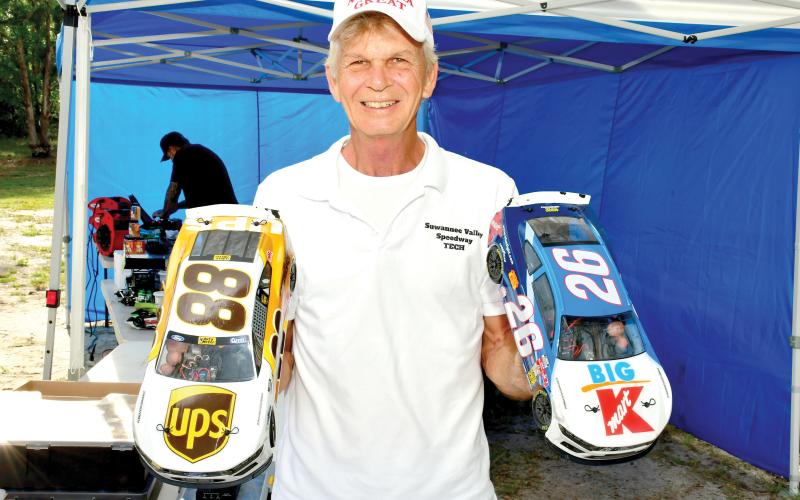 Richard Carroll, the owner of the Suwannee Valley RC Speedway, shows off a pair of the remote control cars that race at the small oval track in Live Oak once a month. (ROB WOLFE/Lake City Reporter)