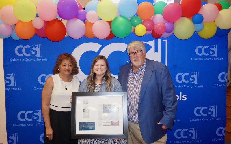 Summers Elementary VPK paraprofessional Kelsie Rodriguez (center) was honored by Columbia School Board member Narrie Smith (left) and Superintendent Keith Couey during Tuesday’s school board meeting. (COURTESY)
