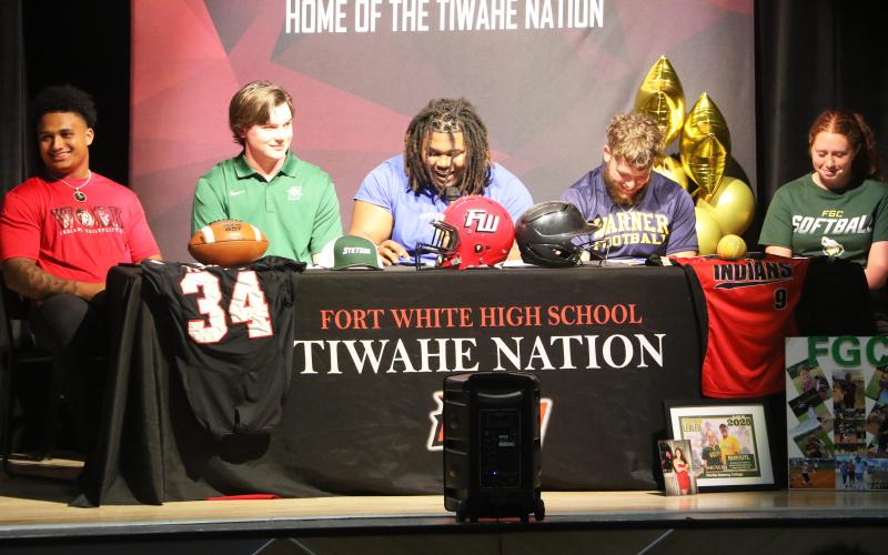 Fort White football players Lecosta Byrd (from left), Kiernen Sheehan, Kingston Anderson, and James Dimauro, as well as softball player Hannah LeBleu, share a laugh during their college signing ceremony on Thursday. Byrd will play at Sussex, Sheehan is headed to Stetson, Anderson signed with Fort Valley State, Dimauro inked with Warner, and LeBleu will suit up for Florida Gateway College. (MORGAN MCMULLEN/Lake City Reporter)