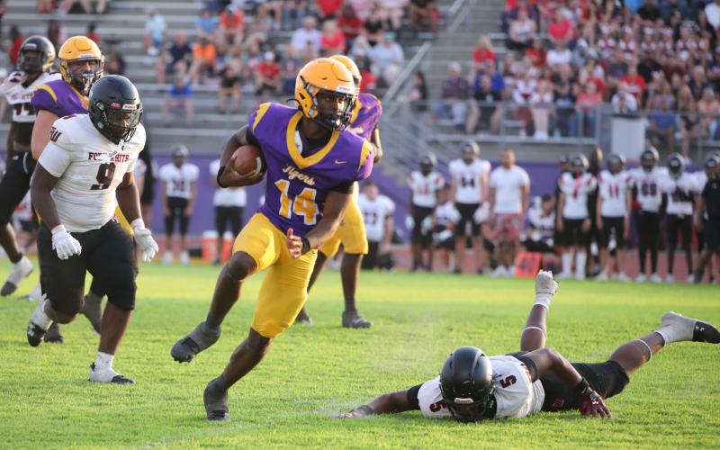 Columbia quarterback Xavier Collins scrambles through the Fort White defense during the teams' spring game on Saturday. (BRENT KUYKENDALL/Lake City Reporter)