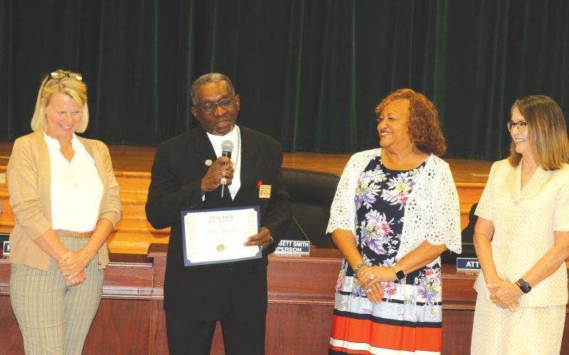 John Brown (second from left) is flanked by Columbia School Board Members Dana Brady-Giddens (from left), Narrie Smith and Cherie Hill after receiving his Teacher of a Lifetime award. (TONY BRITT/Lake City Reporter)