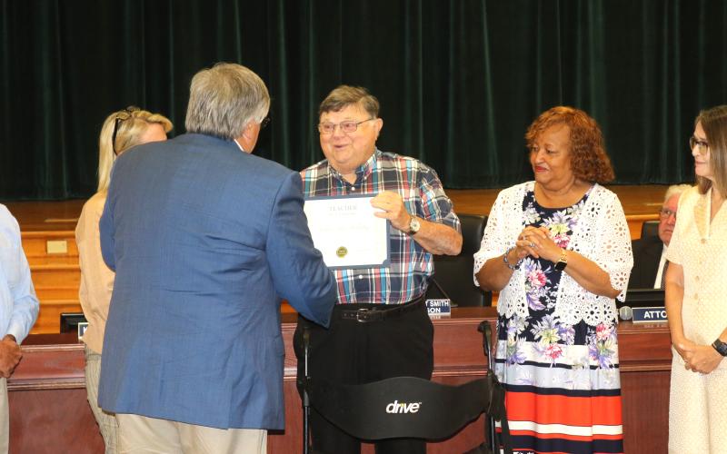 Arthur ‘Art’ Holliday receives his Teacher of a Lifetime award from Columbia Superintendent Keith Couey. (TONY BRITT/Lake City Reporter)