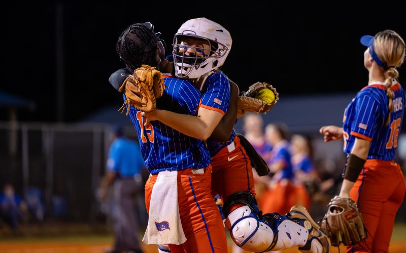 Branford catcher Morgan Brennan (right) celebrates with first baseman Mallory Blue (15) following the final out of the Buccaneers' 6-0 victory over Fort White in the Region 3-R semifinals on Thursday. (JACK HOWDESHELL/Lake City Reporter)
