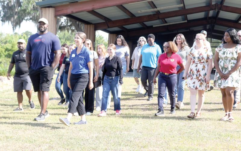 Chris Coleman (from left) and Erin Harlow lead a group of people on a trail tour at Alligator Lake Public Recreation Area on Tuesday morning as part of Economic Development Week activities. (TONY BRITT/Lake City Reporter)
