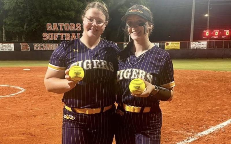 Columbia designated player Josie Raulerson (left) and catcher Emily Delgado show off their home run balls following the Tigers’ 16-0 win over Escambia in the Region 1-4A quarterfinals on Tuesday. (COURTESY)