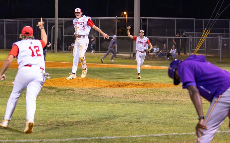 Lafayette pitcher Garrett Taylor (9), Harris Johnson (12) and first baseman Noah Lamb (22) celebrate after the Hornets’ game-ending double play that finished off a 2-1 win over Union County in Game 2 of the Region 3-R finals on Tuesday. (JACK HOWDESHELL/Lake City Reporter)