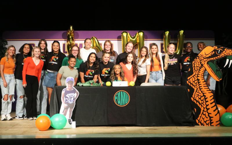 Columbia outfielder Sakiya Merriex (sitting) is surrounded by teammates after signing her letter of intent to play college softball at Florida A&amp;M on Friday. (JORDAN KROEGER/Lake City Reporter)