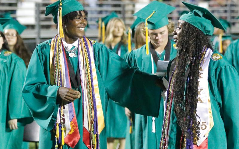 Suwannee graduates Joseph Alicea (left) and Jakiya Washington sing the alma mater during Saturday night’s commencement at Langford Stadium. (JAMIE WACHTER/Lake City Reporter)