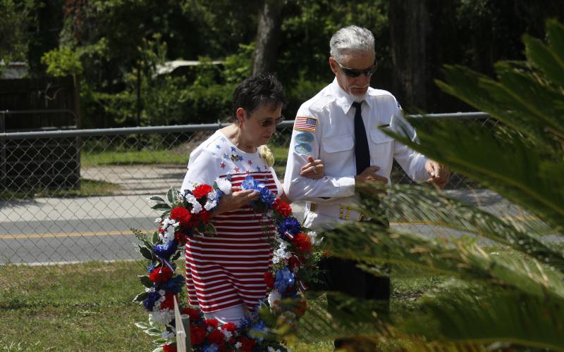 Rosemary Ivie with the Live Oak Garden Club prepares to place a wreath at the veterans memorial during the Memorial Day observance Monday at the Live Oak Cemetery. (JAMIE WACHTER/Lake City Reporter)