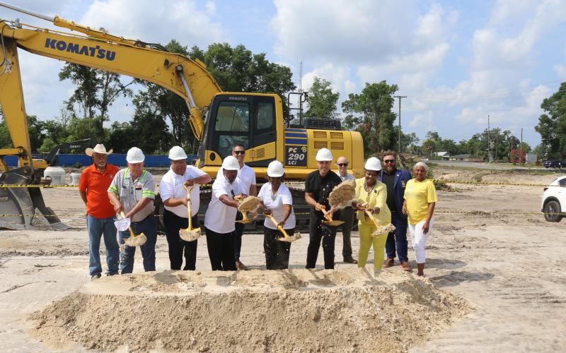 Past and current local officials along with affordable housing and construction officials Ron Williams (from left), Everett Phillips, Troy Wimberly, Lester McKellum, Michael Allan, Mary McKellum, Noah Walker, Steve Auger, Chevella Young, James Carter and Tammy Harris pitch shovels of dirt for the ceremonial groundbreaking of the Sweetwater Phase II apartments on Tuesday morning. (TONY BRITT/Lake City Reporter)