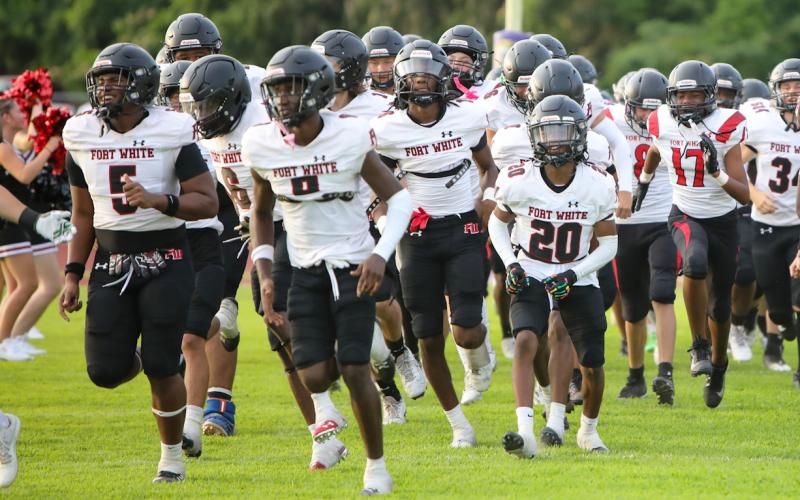 Fort White’s football team takes the field for its spring game against Columbia on May 17. (BRENT KUYKENDALL/Lake City Reporter)