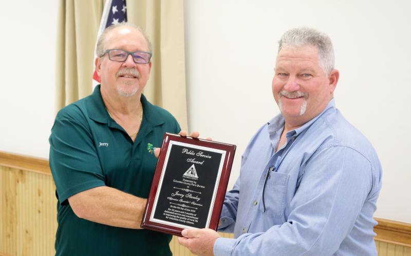 Jerry Stanley (left) was honored with the Public Service Award at the Columbia County Farm Bureau public officials appreciation dinner Monday night. Stanley is presented his plaque by Clint Pittman. (TONY BRITT/Lake City Reporter)