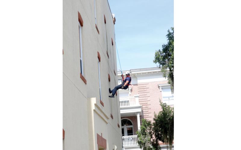 Lake City firefighter Matt Herndon rappels off the side of Lake City Hall during a training session Friday morning. (TONY BRITT/Lake City Reporter)