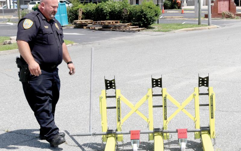 Lt. Garrett Register looks at a modular vehicle barrier on Wednesday. The Lake City Police Department used federal grant funding to obtain the barriers as a way to block off roads during events to protect pedestrians. They will be used for the first time Friday. (TONY BRITT/Lake City Reporter)