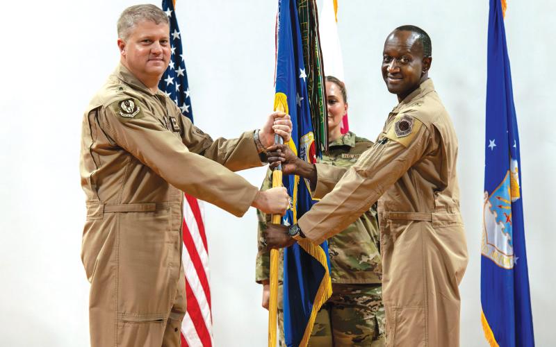 U.S. Air Force Brig. Gen. Travis Edwards, right, 379th Air Expeditionary Wing incoming commander, receives the 379th AEW guidon from Maj. Gen. David Shoemaker, 9th Air Force (Air Forces Central) deputy commander, during the 379th AEW Change of Command Ceremony within the U.S. Central Command area of responsibility, June 9, 2025. (Staff Sgt. Sean Moriarty/U.S. Air Force)
