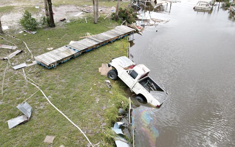 In Horseshoe Beach, near where Hurricane Idalia made landfall, a drone image shows a displaced vehicle spewing gasoline into a neighborhood canal. (MAX CHESNES/Tampa Bay Times/TNS)