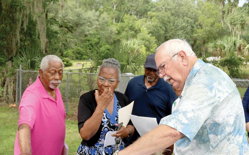 Raymond Brady (from left), Patricia Brady and Terry Harrell look on as Chuck Denmark, a trustee of Bethel Community Cemetery, uses a map to show property lines and easement for the Brady-Jones Bethel Community Cemetery. Bethel Community Cemetery trustees recently gave Brady-Jones Bethel Community Cemetery trustees a deed to the cemetery which is adjacent to Bethel Community Cemetery. (TONY BRITT/Lake City Reporter)