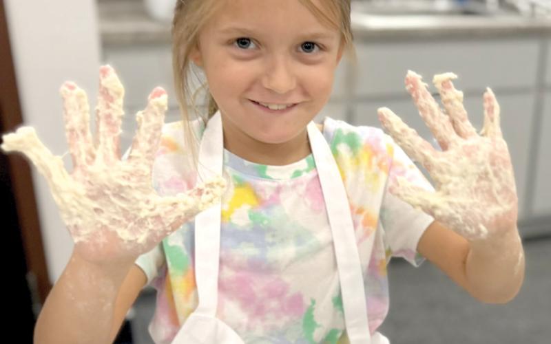 Tara Markham shows hands full of dough after mixing her first sourdough loaf. (COURTESY)