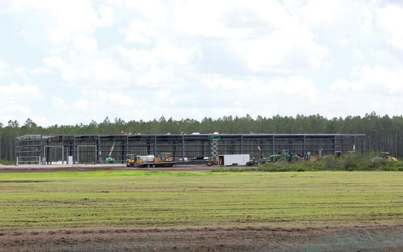 Work continued Friday on the 48,335-square-foot facility for AgroLiquid at the North Florida Mega Industrial Park. The grass parcel in front of the AgroLiquid facility is being eyed by a foreign steel manufacturer, according to county officials. (TONY BRITT/Lake City Reporter)