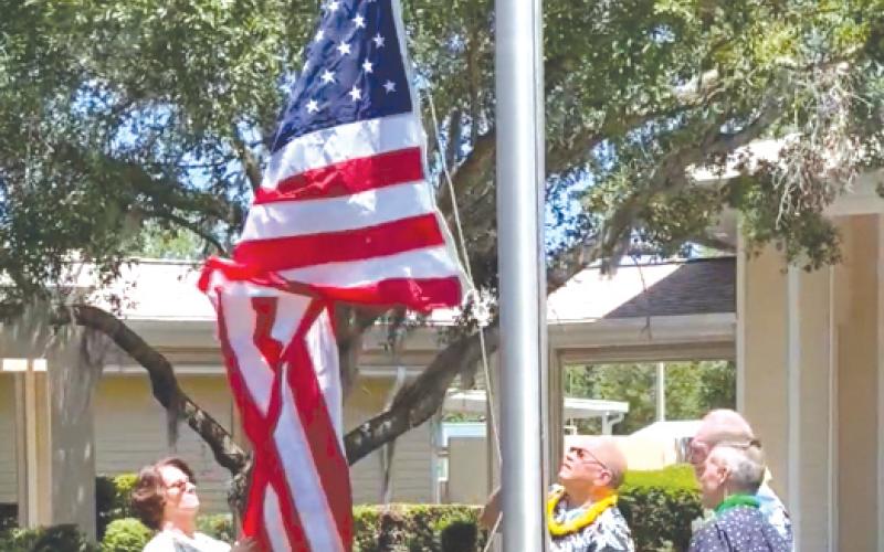 Volunteers raise the American flag outside of Haven Hospice. (COURTESY)