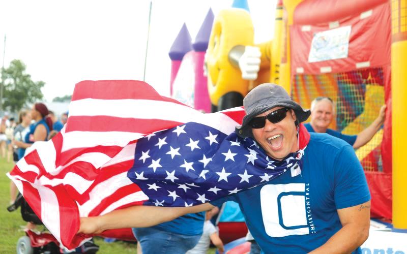 Earnest Burch waved down festival-goers with his Old Glory cape at the 2019 Independence Day event at the Columbia County Fairgrounds. (FILE)