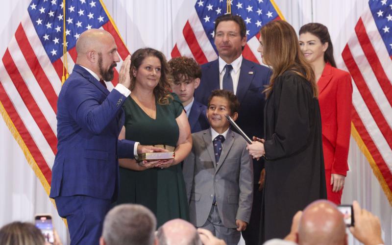 Jay Collins, a former Green Beret and decorated veteran, left, is sworn in as Florida’s new lieutenant governor by Florida Supreme Court Justice Jamie Grosshans on Tuesday in Tampa. He is joined by his wife, Layla, and their sons, Gabe and Colt. At right, Florida Gov. Ron DeSantis stands with his wife, Casey DeSantis. (DOUGLAS CLIFFORD/Tampa Bay Times/TNS)