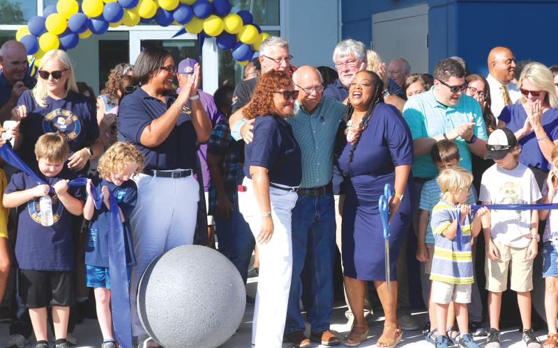 School Board members Narrie Smith (center) and Keith Hudson share a hug with Niblack Elementary School principal Makeba Murphy after she cut the ribbon for the new school on Thursday morning. (TONY BRITT/Lake City Reporter)