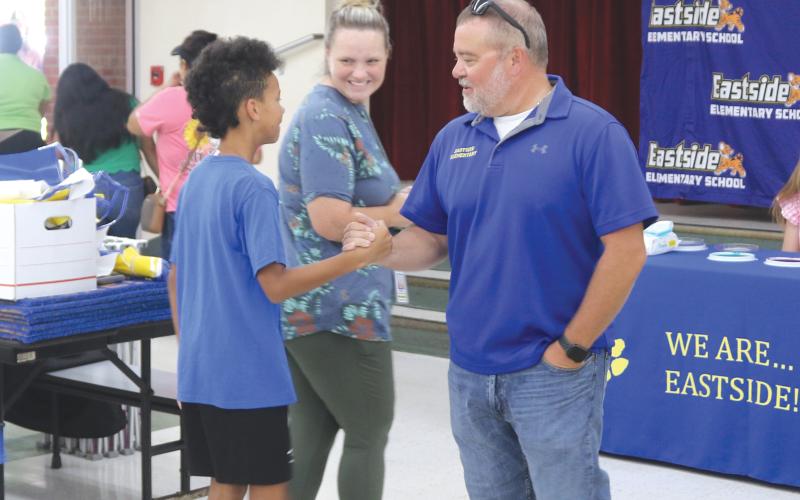 Roger Little (right), Eastside Elementary School principal, greets parents and students as they visit the temporary cafeteria on Thursday during a school Sneak Peak session. More than 100 people visited the school during the session. (TONY BRITT/Lake City Reporter)