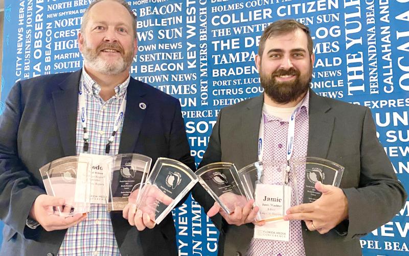 Lake City Reporter Publisher Todd Wilson (left) and Editor Jamie Wachter hold up the first-place awards that the Reporter and sister publication Nassau County Record captured last week in the Florida Press Association Weekly Newspaper Contest. (COURTESY)