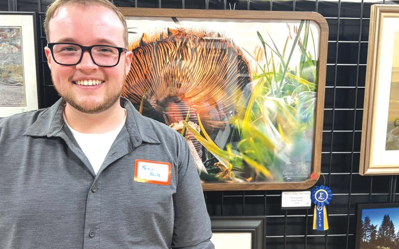 Kevin Paulk stands in front of his winning photograph, ‘With an Edge &amp; Charm,’ during Saturday’s photo contest reception hosted at the Gateway Art Gallery. Paulk won a $125 cash prize in the second contest put on by the Branford Camera Club. (COURTESY)