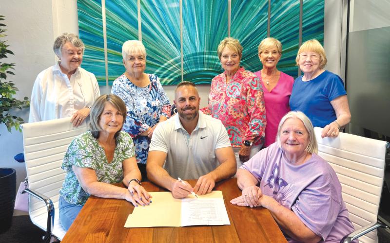 Josh Sparks, owner of Sparks Construction, is pictured with members of the Lake City Women’s Club and Lake City Garden Club, after signing the deed to the historic Club House on Lake Isabella. Sparks was given ownership of the building so he can repair and save the facility. (COURTESY)
