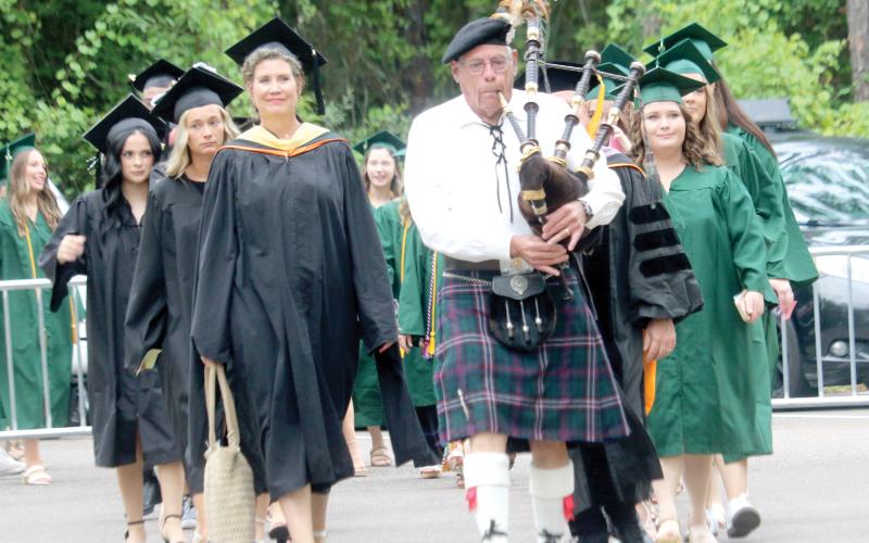 A First Coast Highlanders bagpipe player leads the procession of Florida Gateway College professors and graduation candidates into the gymnasium on Thursday evening for the school’s summer graduation ceremony. (TONY BRITT/Lake City Reporter)