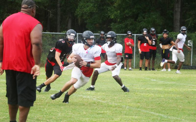 Fort White quarterback Matthew Pitts scrambles during 11-on-11s at Monday’s practice. (MORGAN MCMULLEN/Lake City Reporter)