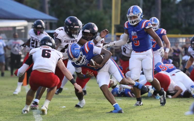 Fort White linebacker Carson Lumpkin (17) and defensive back Matthew Pitts gang up to tackle Taylor County quarterback Janez Glanton on Friday. (MORGAN MCMULLEN/Lake City Reporter)