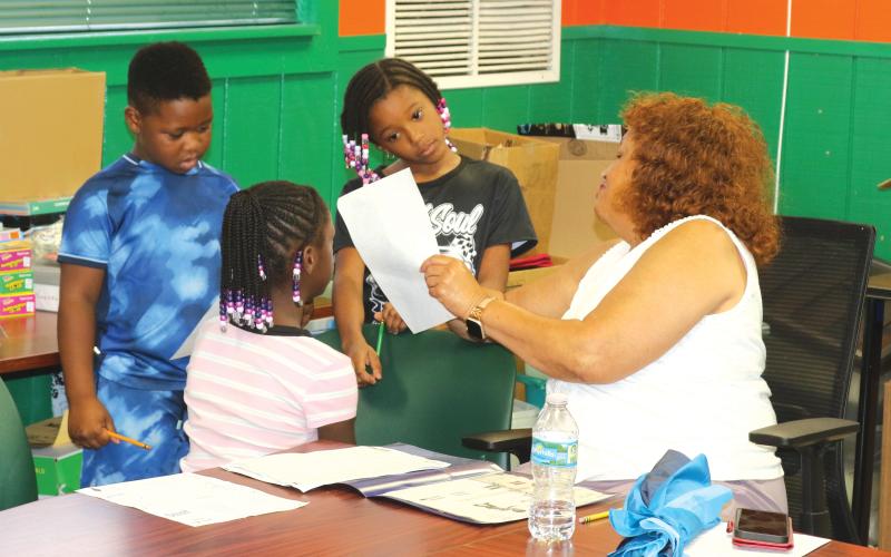 Narrie Smith, a retired Columbia County School District educator, helps children with their homework while they are at the NorthStar Family Resource Center on Tuesday afternoon. (TONY BRITT/Lake City Reporter)