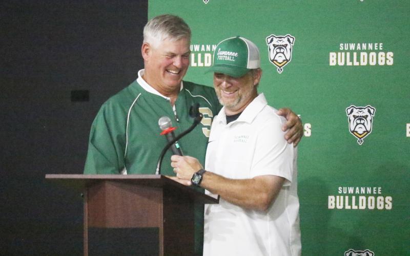 Bill Ragans (left) and Kyler Hall share a hug and a laugh during the Suwannee football 100-year celebration Friday night at the Suwannee Coliseum. (JAMIE WACHTER/Lake City Reporter)