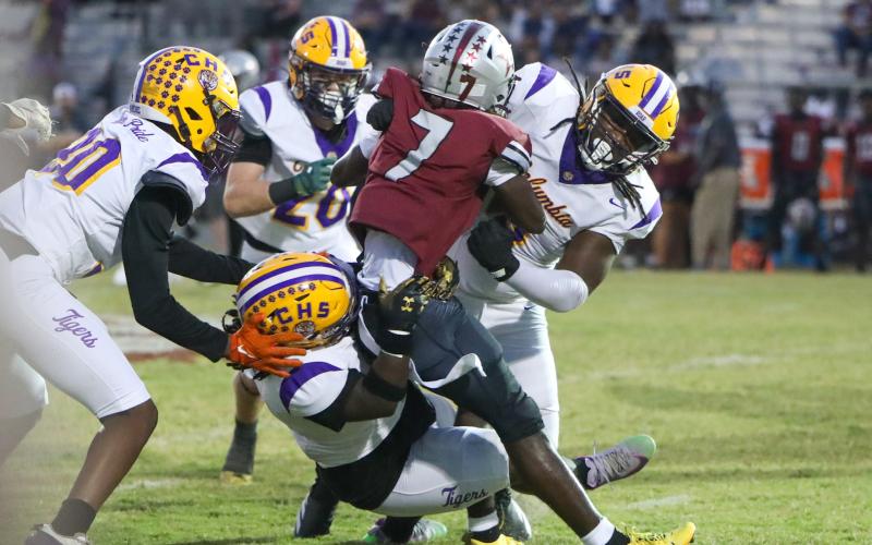Columbia defensive linemen Jaylen Underwood (right) and Terry Henry (bottom) stuff Madison County running back Davyon Gallon on Friday night at Boot Hill. (BRENT KUYKENDALL/Lake City Reporter)