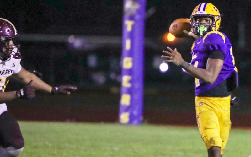 Columbia quarterback Xavier Collins rolls out to pass against Coffee last Friday. (BRENT KUYKENDALL/Lake City Reporter)