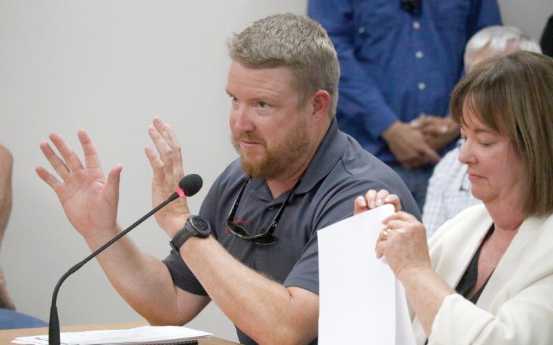 Stephen Douglas, a co-owner of Suwannee Iron Works, speaks during a public hearing Tuesday night in front of the Suwannee County Commission on the company’s request for a special exception to the county’s zoning and Land Development Regulations. Seated next to Douglas is Emily Pierce, one of the company’s attorneys. (JAMIE WACHTER/Lake City Reporter)