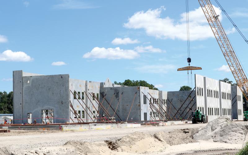 Construction crews continue progressing with the work at the new Eastside Elementary Schools with concrete walls for the first floor of the new building lifted into place this week. (TONY BRITT/Lake City Reporter)