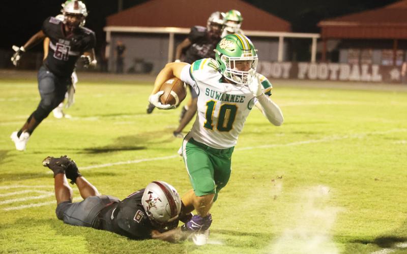Suwannee receiver Koy Frier is tackled from behind by Madison County defensive end Brandon Williams on Friday. (PAUL BUCHANAN/Lake City Reporter)