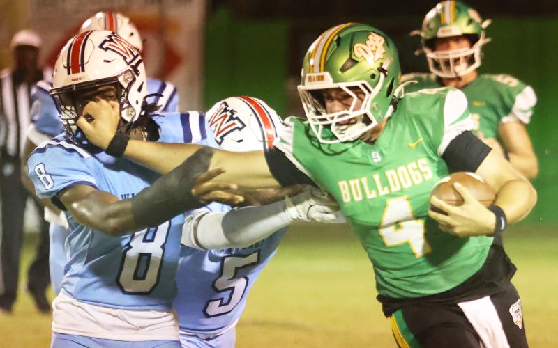 Suwannee quarterback Thomas Sikes stiff-arms Wakulla’s Rayshon St. Hilaire on a run Friday night. (PAUL BUCHANAN/Lake City Reporter)