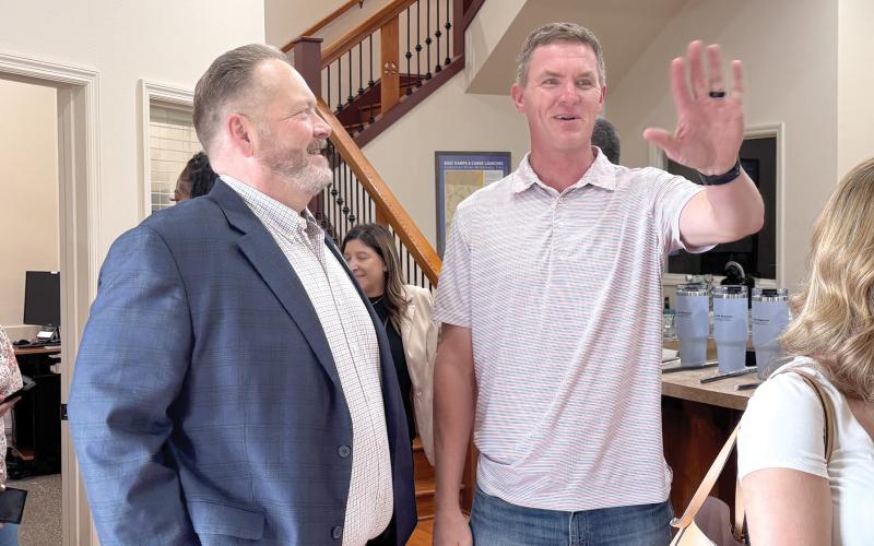 Todd Wilson (left), the publisher of the Lake City Reporter and Live Oak Reporter, speaks with Suwannee County Parks and Recreation Director Alden Rosner during the Reporter’s mix and mingle at its Live Oak office last month. (JAMIE WACHTER/Lake City Reporter)